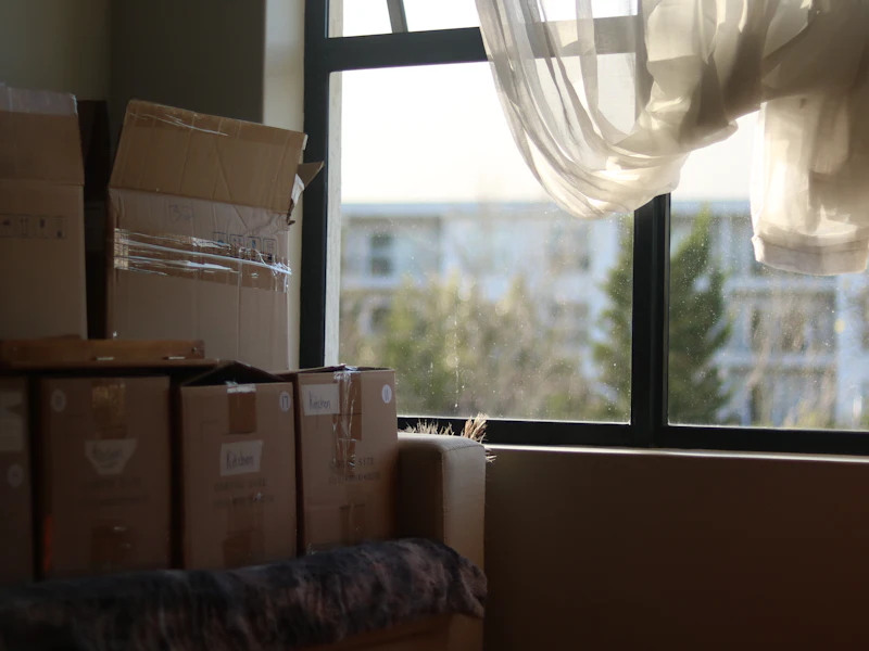 Packed moving boxes stacked by the window of a Dubai apartment on moving day