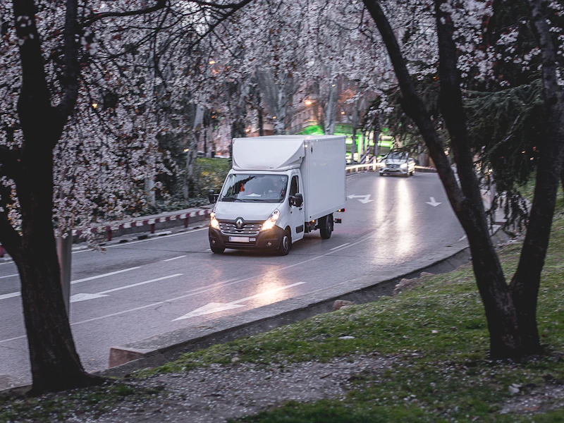 White box removal truck transporting household furniture on the road